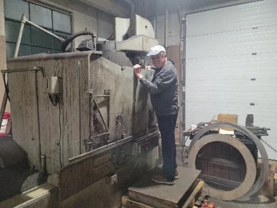 Team member working at a large industrial machine in the Buchanan shop